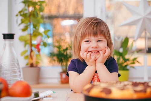 little girl standing at a counter in Corona CA smiling and about to cook